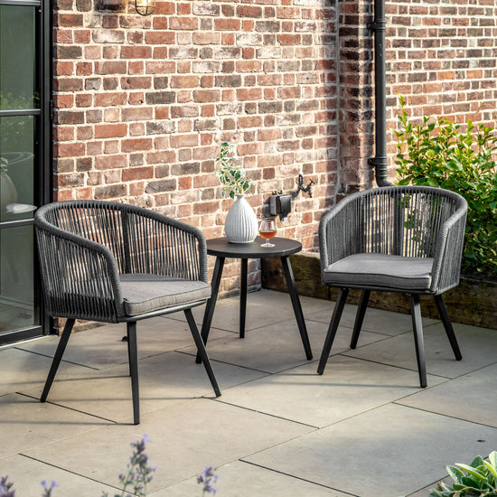 Two Prawle 2 Seater Bistro/Tea Set chairs and a table on a patio for home furniture.
