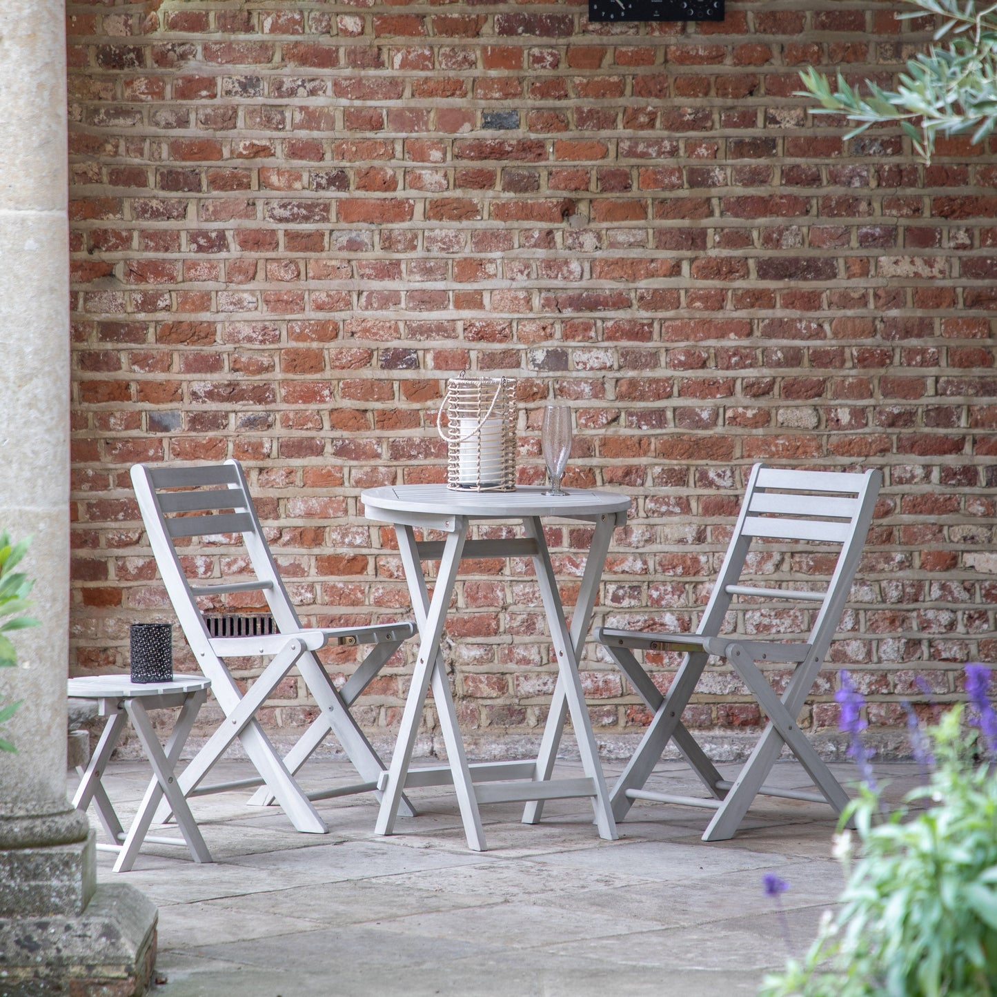 A Chillington 2 Seater Bistro Set Whitewash by Kikiathome.co.uk enhancing interior decor on a brick patio.