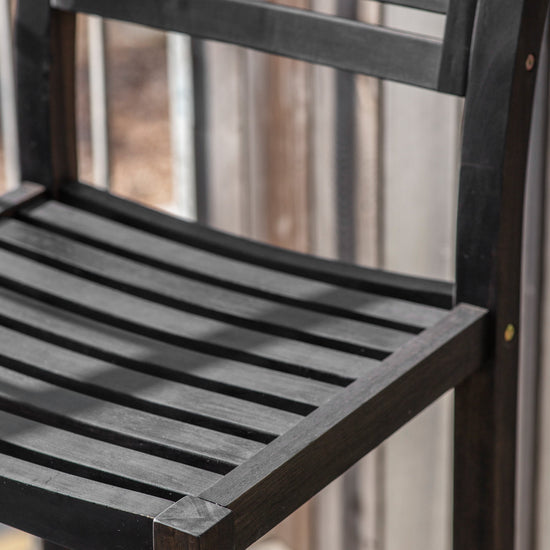 A close up of a black Alfrington 2 Seater High Bar Set Black patio chair by Kikiathome.co.uk, perfect for interior decor.