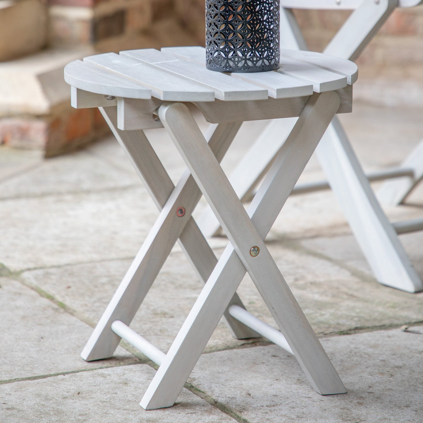 A Chillington Side Table, an interior decor piece from Kikiathome.co.uk, featuring a whitewash finish and adorned with a candle.