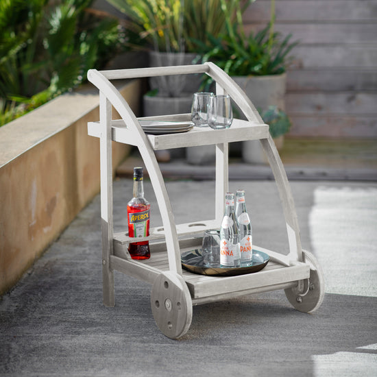 A Alfrington Drinks Trolley Whitewash with a bottle of wine on it, perfect for home furniture and interior decor.