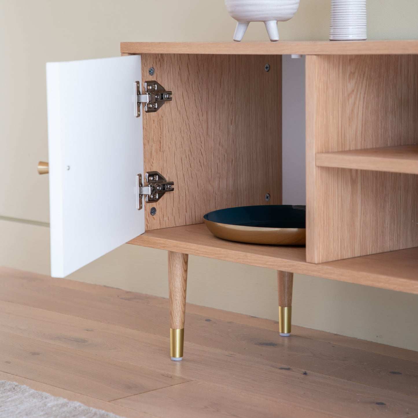 An oak and white media unit cabinet with a bowl on top, perfect for interior decor and home furniture.