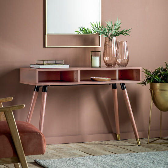 A pink console table with a mirror and a potted plant, perfect for interior decor.