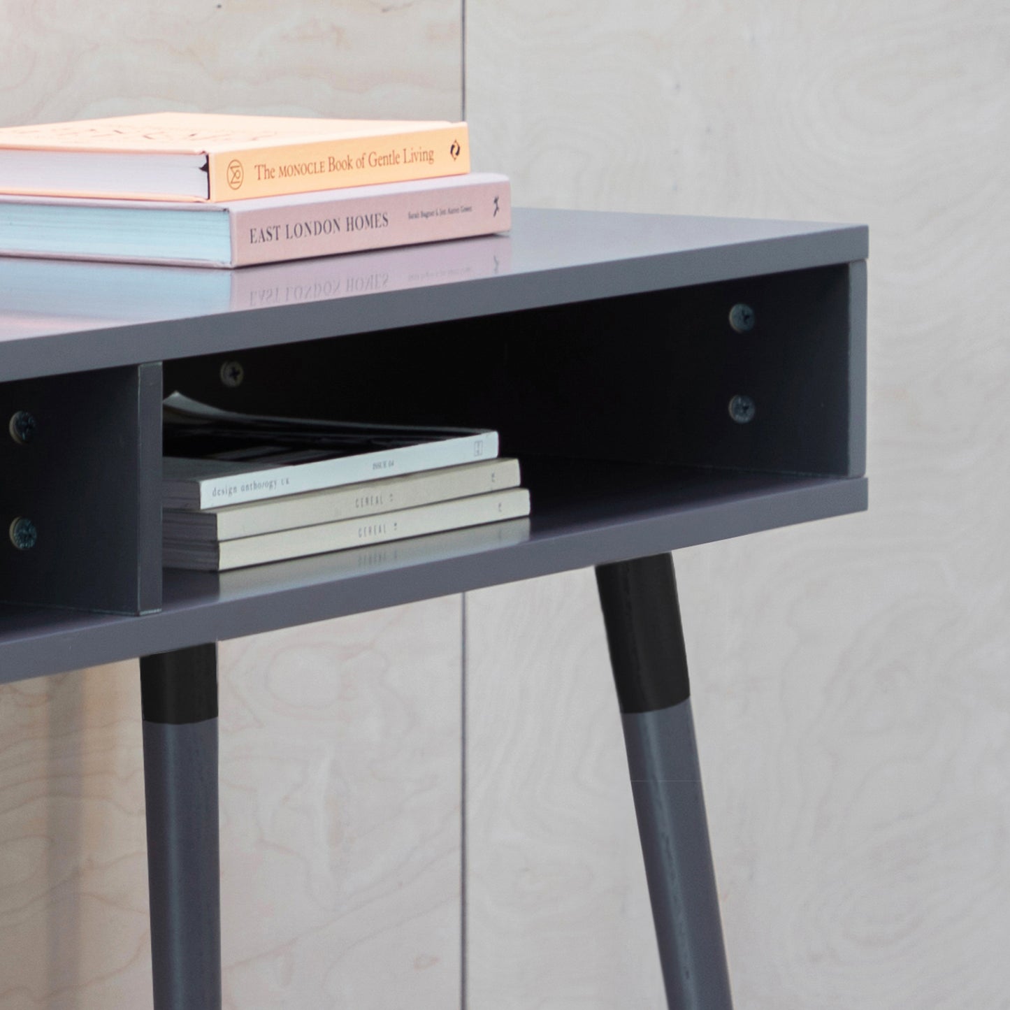 A grey Thurlestone console table, 1100x450x770mm with a book on top, perfect for interior decor and home furniture.