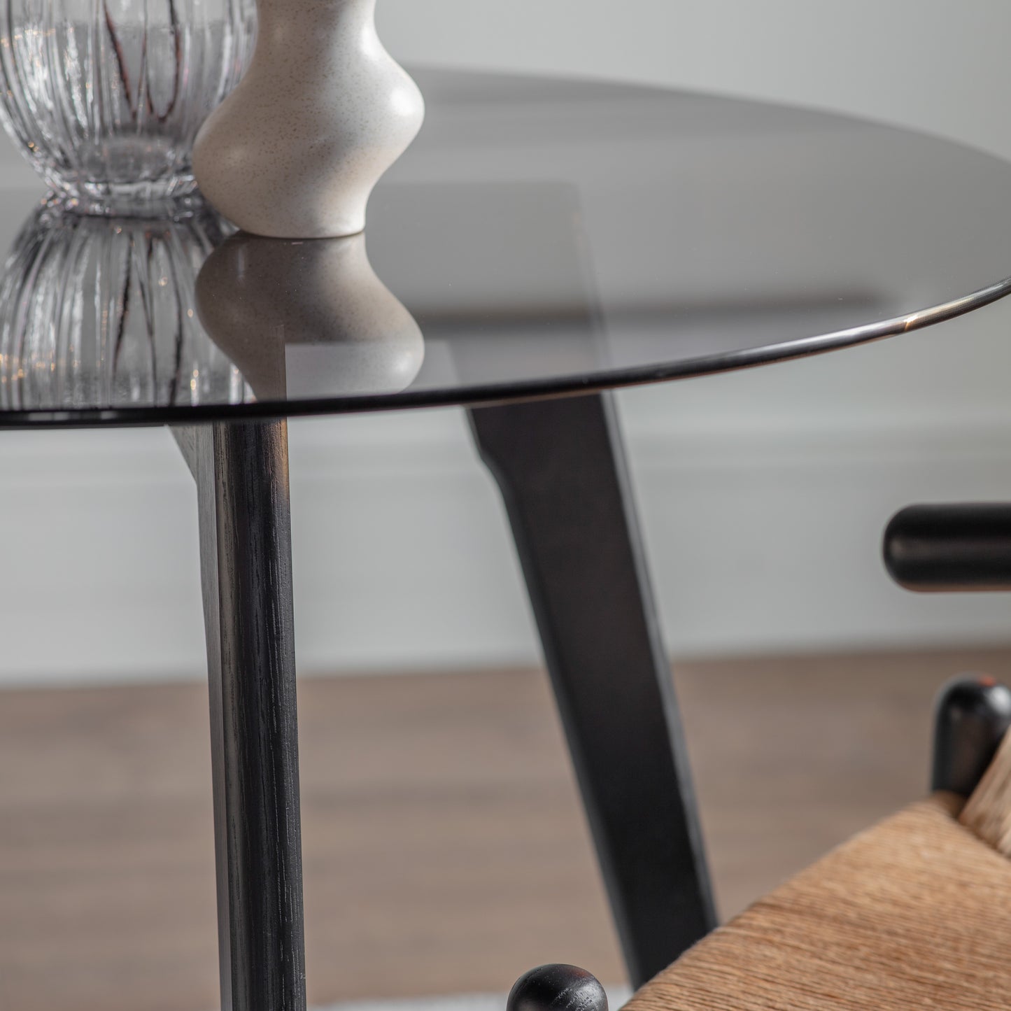 A stylish Ashprington Round Dining Table in Black with a glass top for interior decor or home furniture.