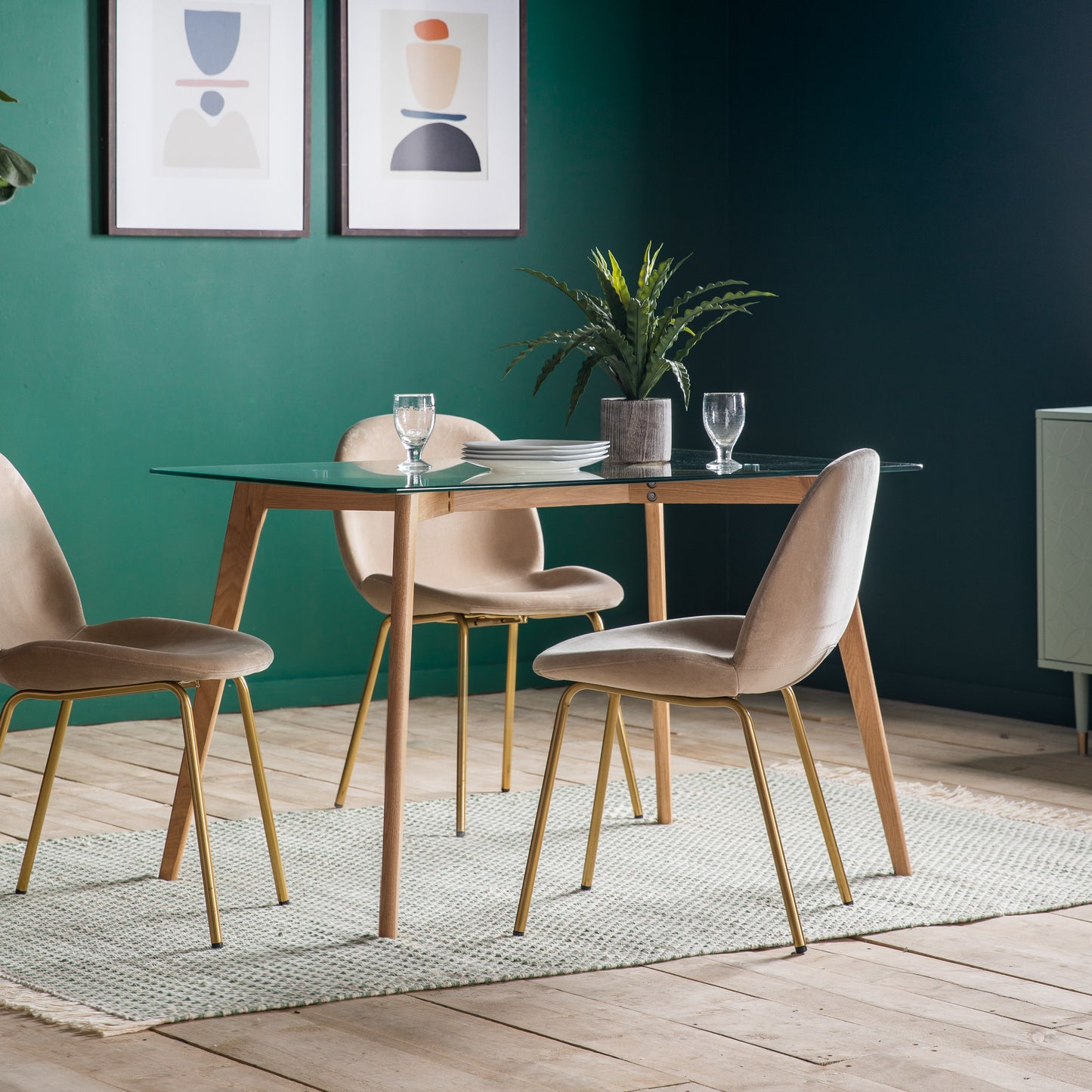 An Oak dining table and chairs, perfect for home furniture and interior decor, in a room with green walls from Kikiathome.co.uk.