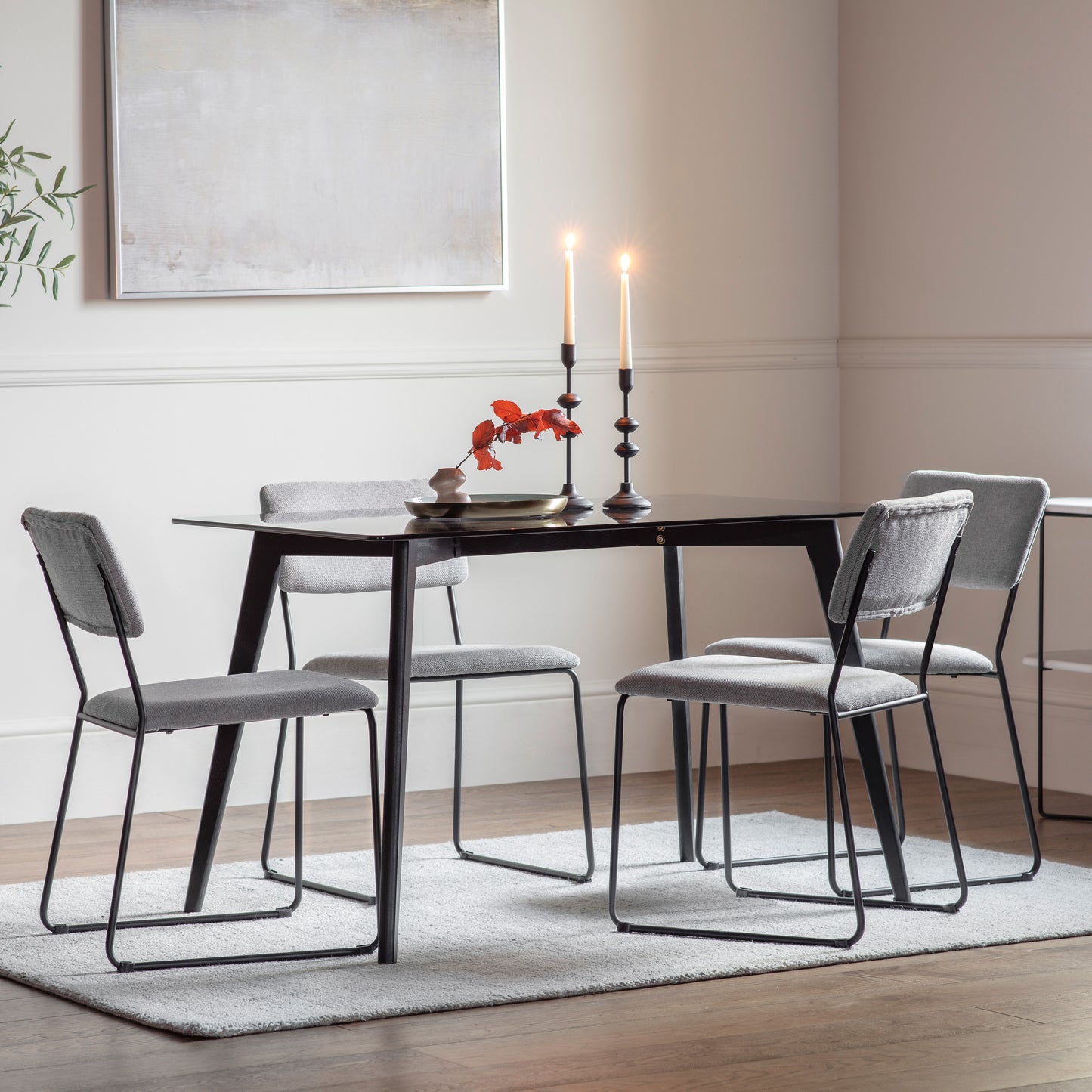 An Ashprington Rectangle Dining Table Black 1200x800x750mm with four chairs and a vase, perfect for interior decor and home furniture, from Kikiathome.co.uk.