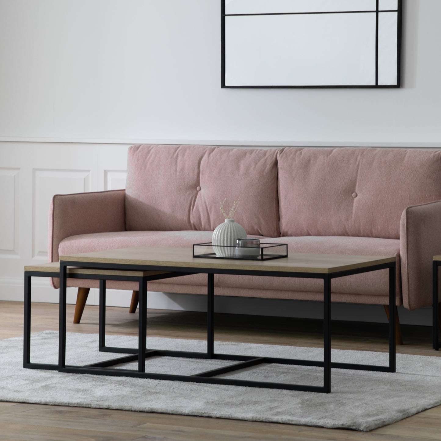 A living room with a pink couch and Staverton Coffee Table Nest from Kikiathome.co.uk, showcasing home furniture and interior decor.