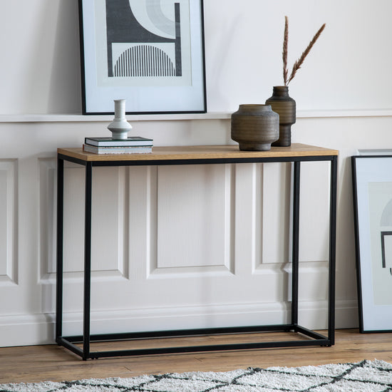 A Staverton Console Table with a black frame and wooden top for interior decor from Kikiathome.co.uk.