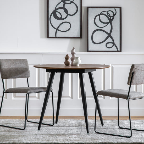A 900x900x750mm Ashford Round Dining Table Oak and two chairs for interior decor from Kikiathome.co.uk.
