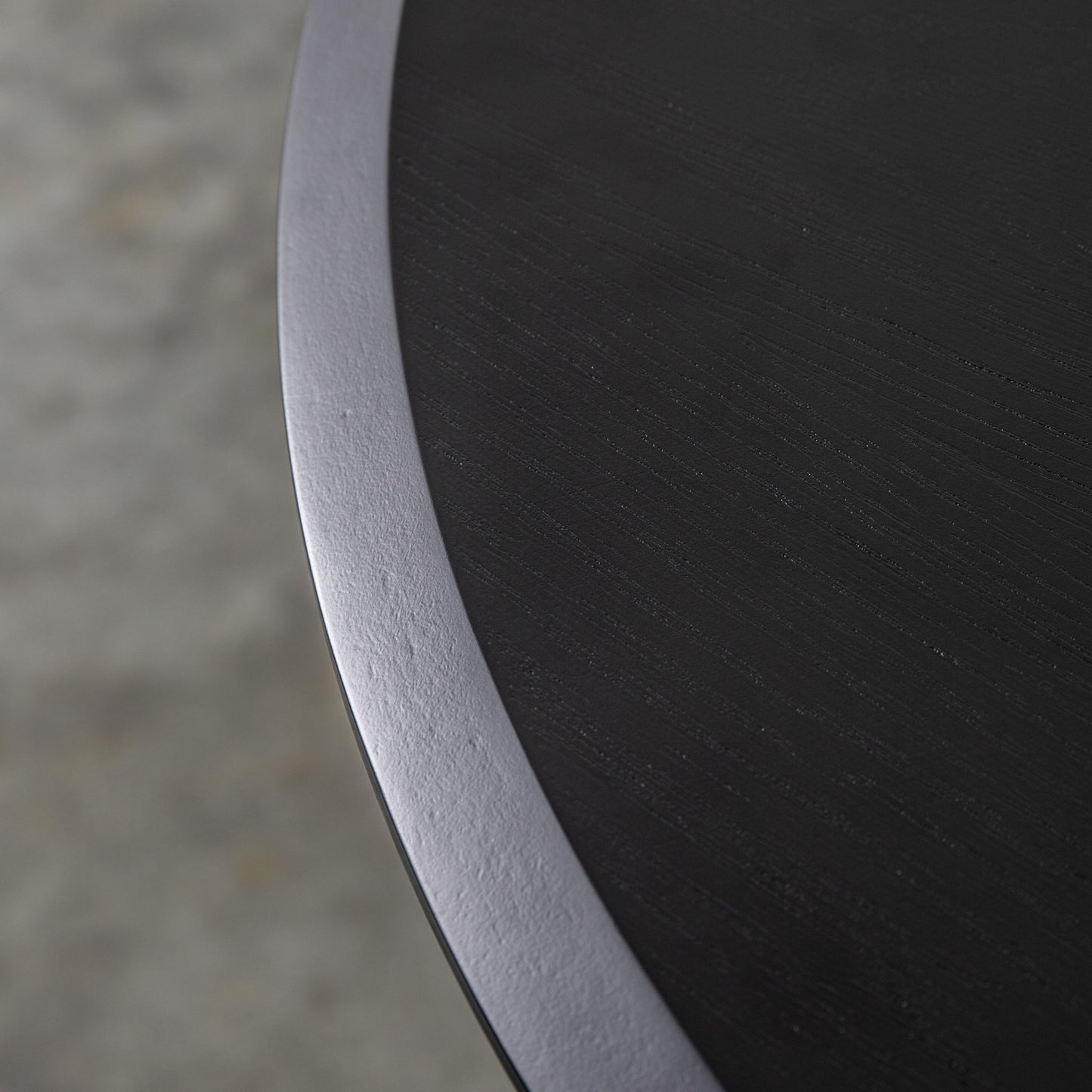 A close up of a Maddox Round Dining Table with a metal base, suitable for interior decor and home furniture.
