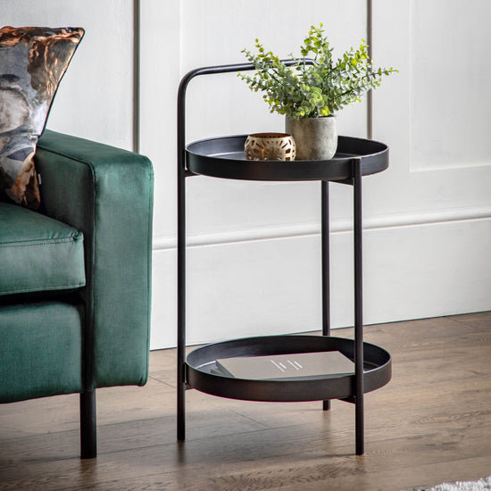 A Sennen Side Table Black 400x400x720mm from Kikiathome.co.uk complements interior decor as it sits next to a green couch.
