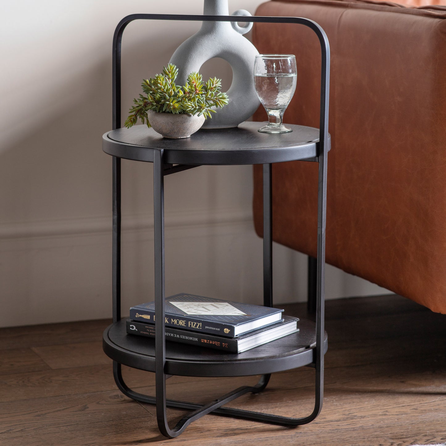 A Kikiathome.co.uk Lutton Side Table Black 425x425x720mm with a vase and books - perfect home furniture for interior decor.