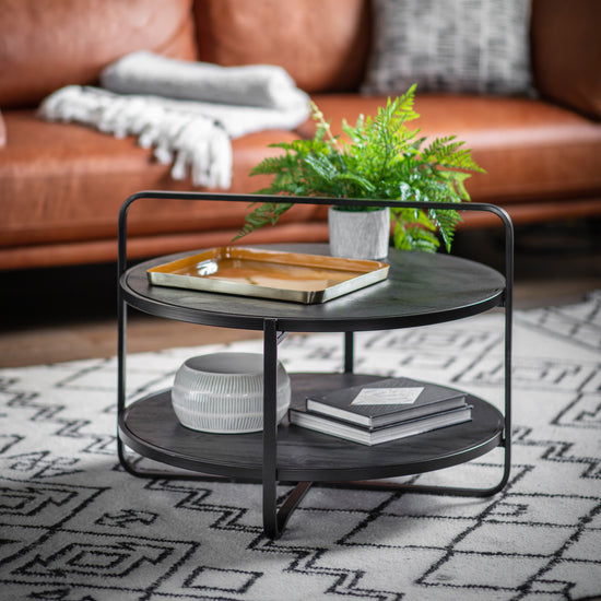 A Lutton Coffee Table in Black 650x650x500mm from Kikiathome.co.uk adorned with a plant, perfect for home furniture and interior decor.