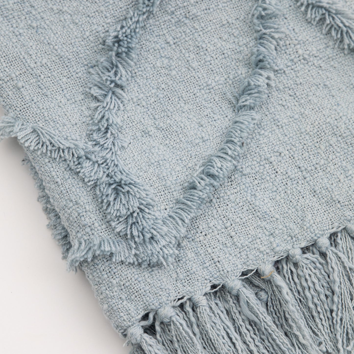 A SG Miami Tufted Throw Blue 1300x1700mm with fringes and tassels perfect for interior decor from Kikiathome.co.uk.