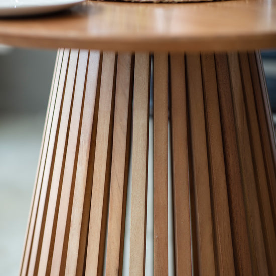 A close up of a Ditsum Slatted Dining Table from Kikiathome.co.uk adorned with a flower, perfect for home furniture and interior decor.