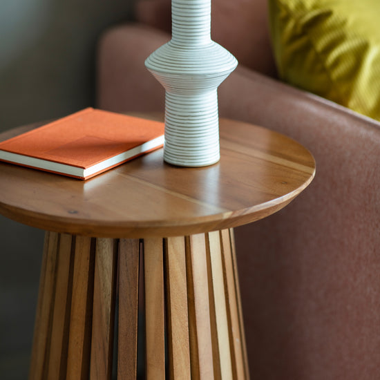 A Ditsum slatted side table with a vase and a book, perfect for home furniture and interior decor.