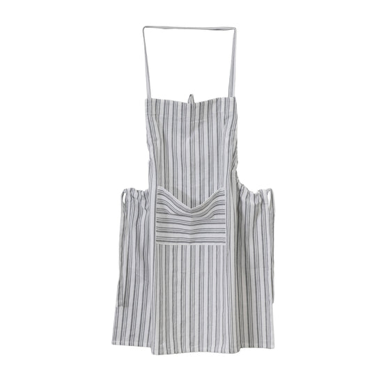 An Organic Cotton Apron with grey and white stripes, is hanging on a white background.