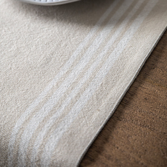 Interior decor: A white and beige Stripe Reversible Table Runner Natural 360x1800mm by Kikiathome.co.uk on a wooden table, perfect for enhancing home interiors.