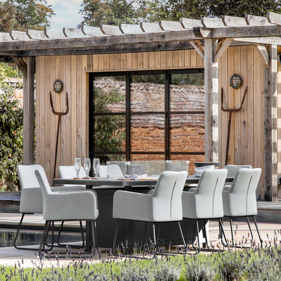 A stylish Ferrers 8 Seater Dining Set with Fire Pit Table Slate for outdoor entertainment and dining, ideal for home furniture and enhancing interior decor.