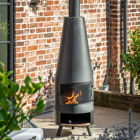 A Monkleigh Chiminea with Pizza Shelf 500x500x1865mm from Kikiathome.co.uk sits on a brick patio, serving as both home furniture and interior decor.