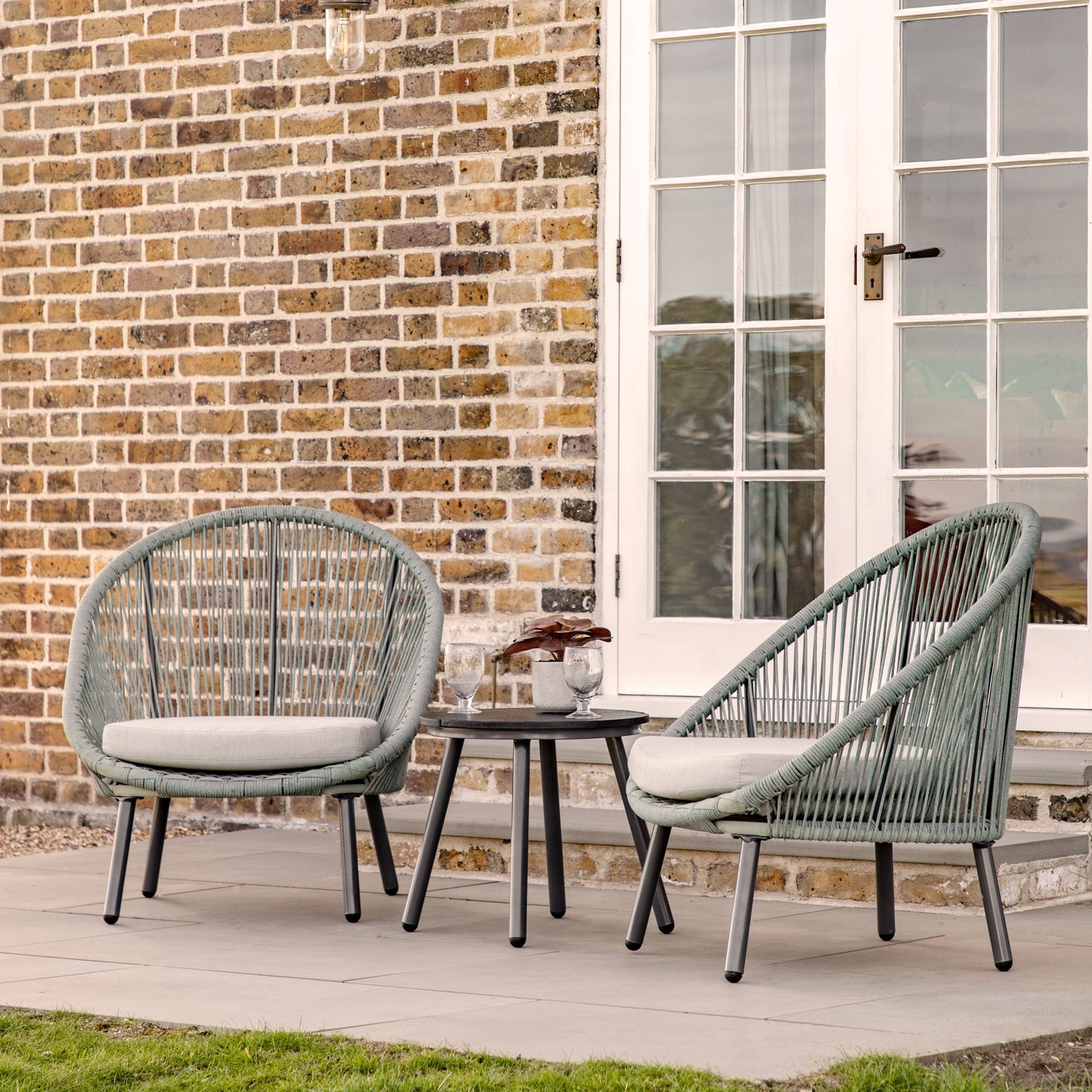 Two Lamerton 2 Seater Bistro Set Sage chairs from Kikiathome.co.uk adding style to interior decor in front of a brick wall.