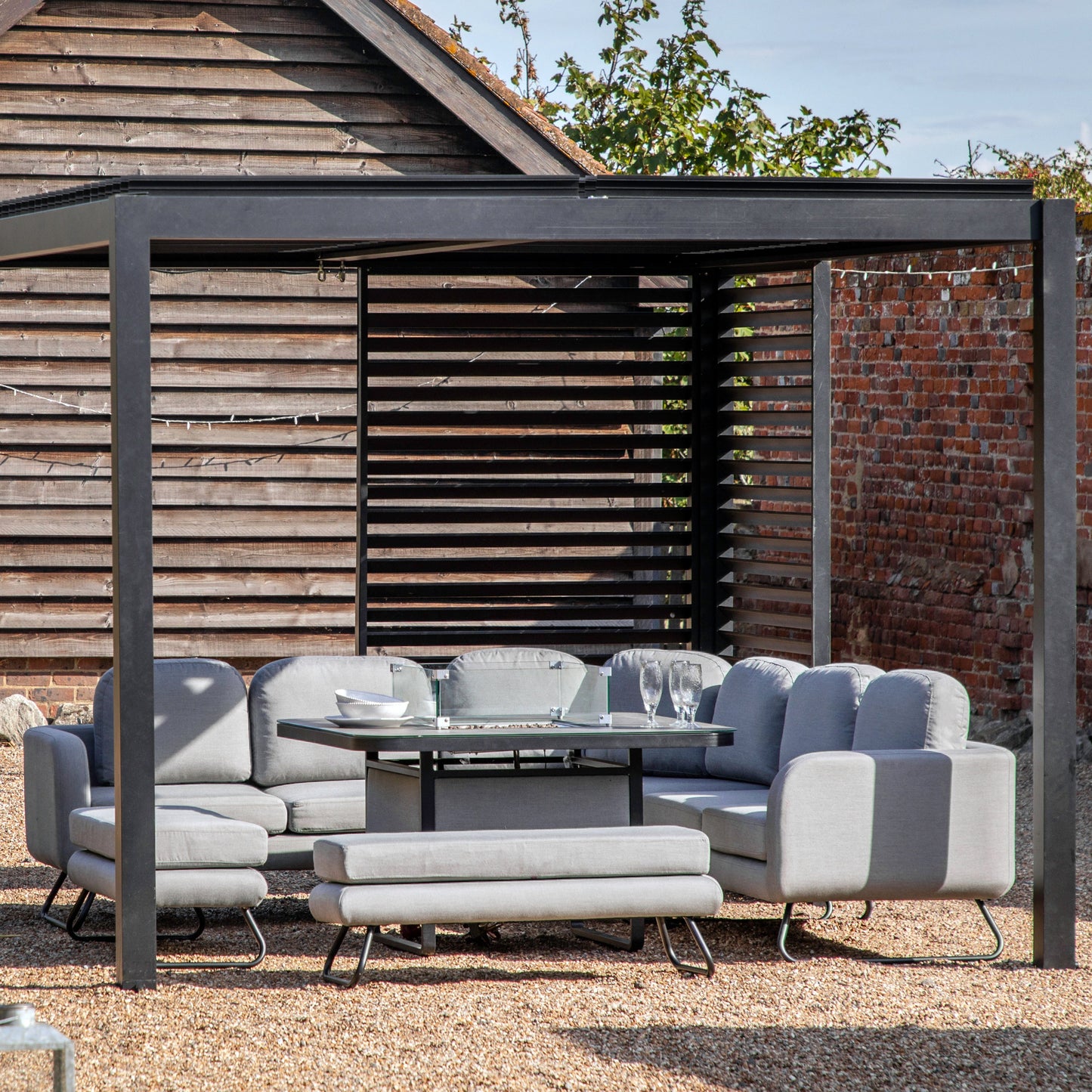 A Dittisham Pergola Louvre Screen Black 1230x2180mm by Kikiathome.co.uk enhancing home furniture with a table and chairs.