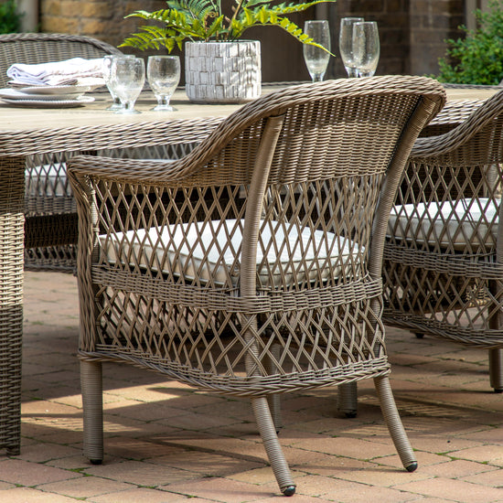A Ringmore 6 Seater Dining Set from Kikiathome.co.uk on a brick patio, perfect for interior decor and home furniture.