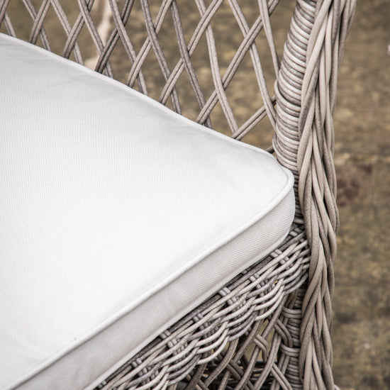 A close-up of the Allington Bistro Set Stone wicker chair with a white cushion, perfect for interior decor and home furniture enthusiasts from Kikiathome.co.uk.