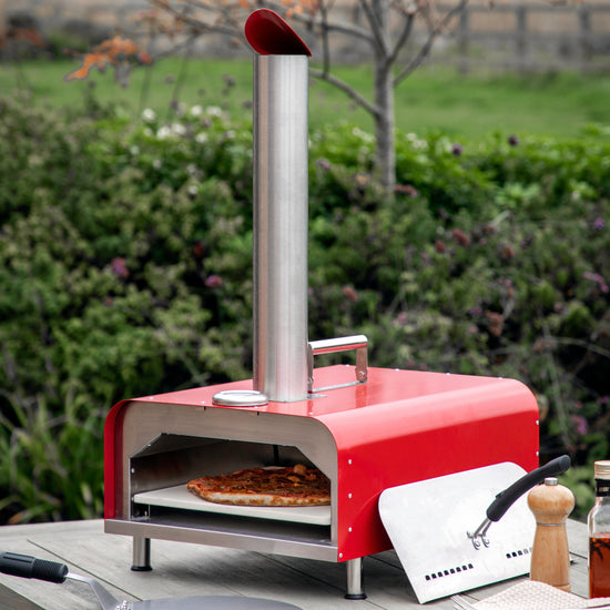 A Brixham Pellet Pizza Oven Red on a table, perfect for interior decor or home furniture.