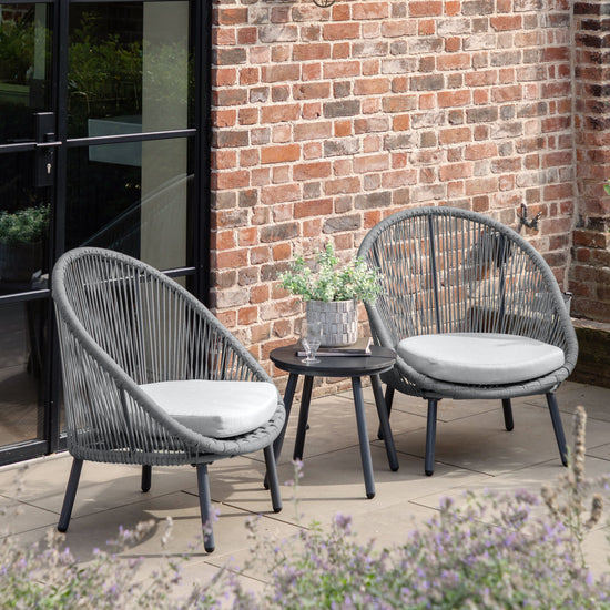 Two Lamerton 2 Seater Bistro Set Charcoal lounge chairs on a brick patio, perfect for interior decor.