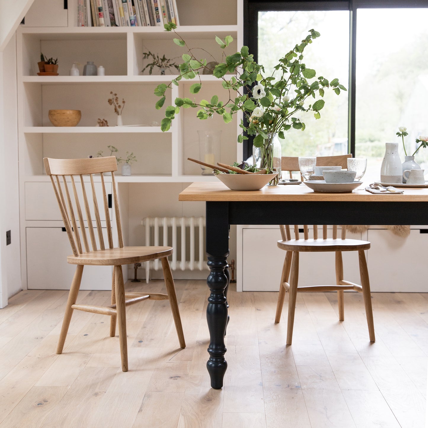 A pair of Oak Spindle Back Dining Chairs by Kiki in a kitchen, perfect for interior decor and home furniture.