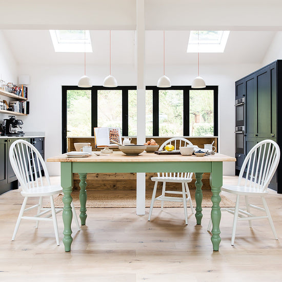 A kitchen with French interior decor featuring a rustic oak dining table by Kiki and home furniture chairs.