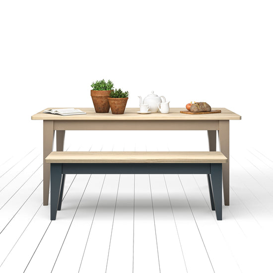 Interior Decor: A wooden table adorned with a stylish Ash Bench from Kiki and accompanied by potted plants.