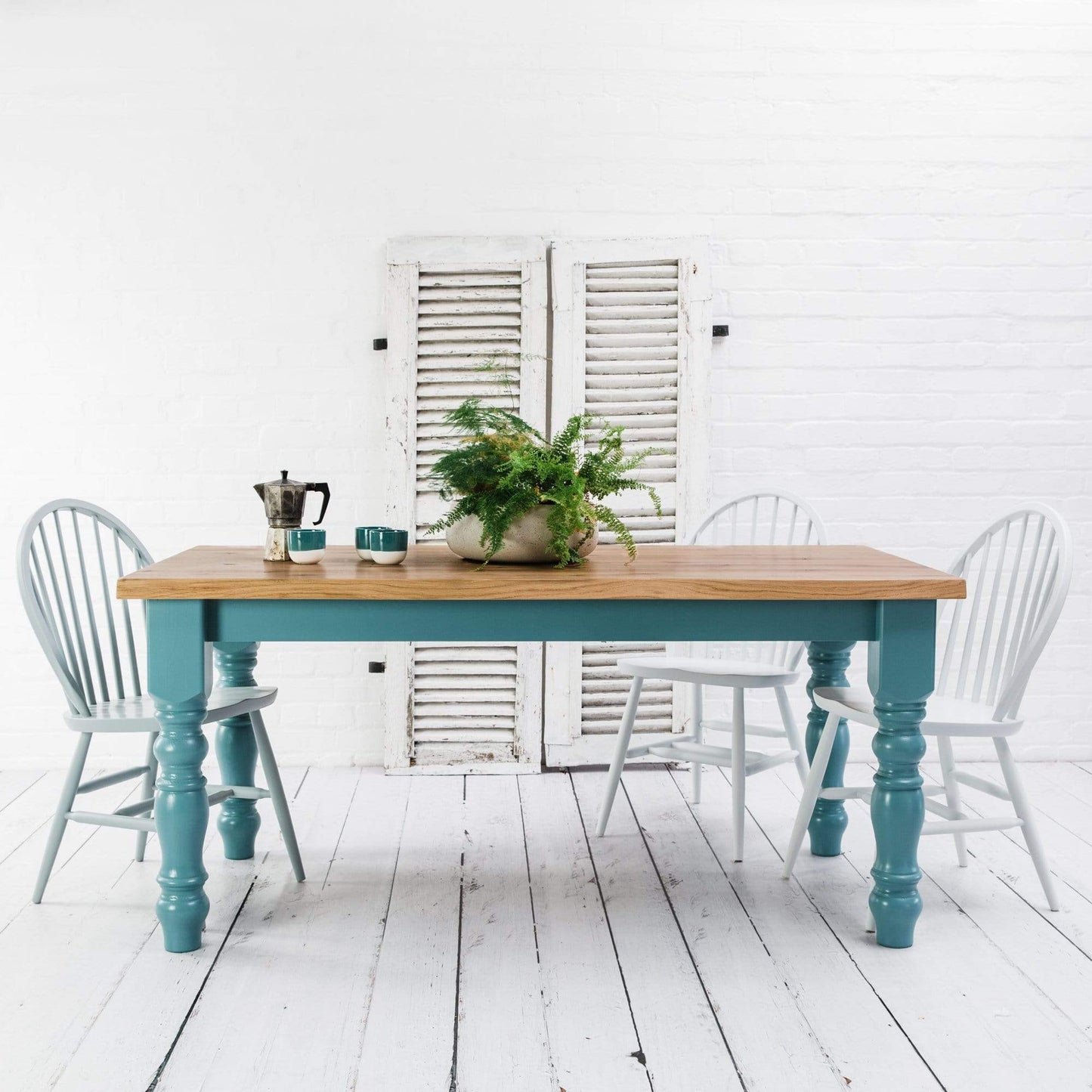 A rustic oak dining table with white chairs, perfect for your interior decor.